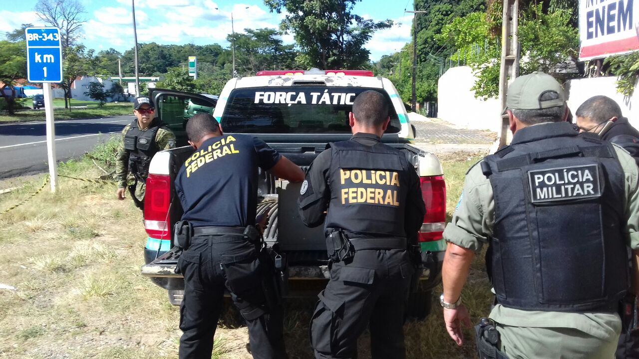 Cofres sendo colocados na viatura da PM