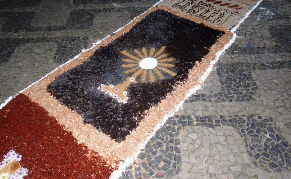 No tapete são desenhados símbolos da Igreja