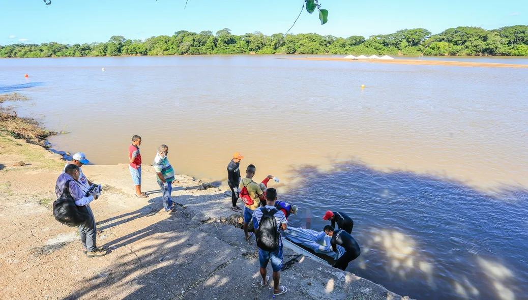 Corpo sendo retirado do rio