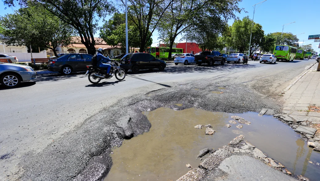 Carros  e ônibus passam com dificuldades pelo local