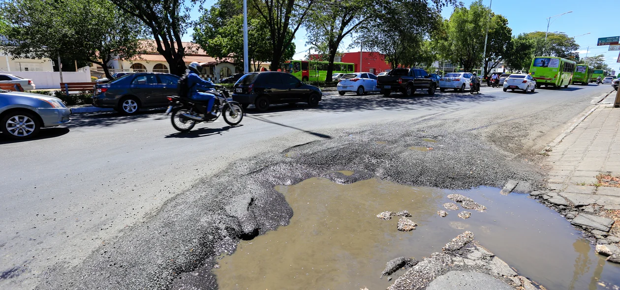 Carros  e ônibus passam com dificuldades pelo local