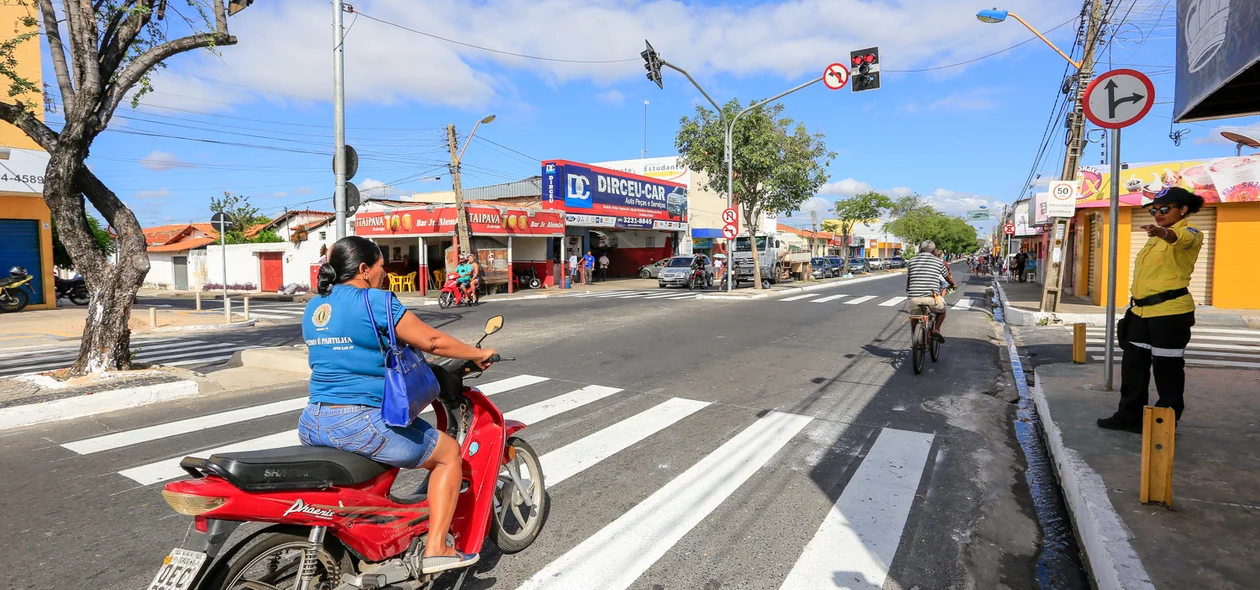 Mulher para em cima da faixa e sem capacete