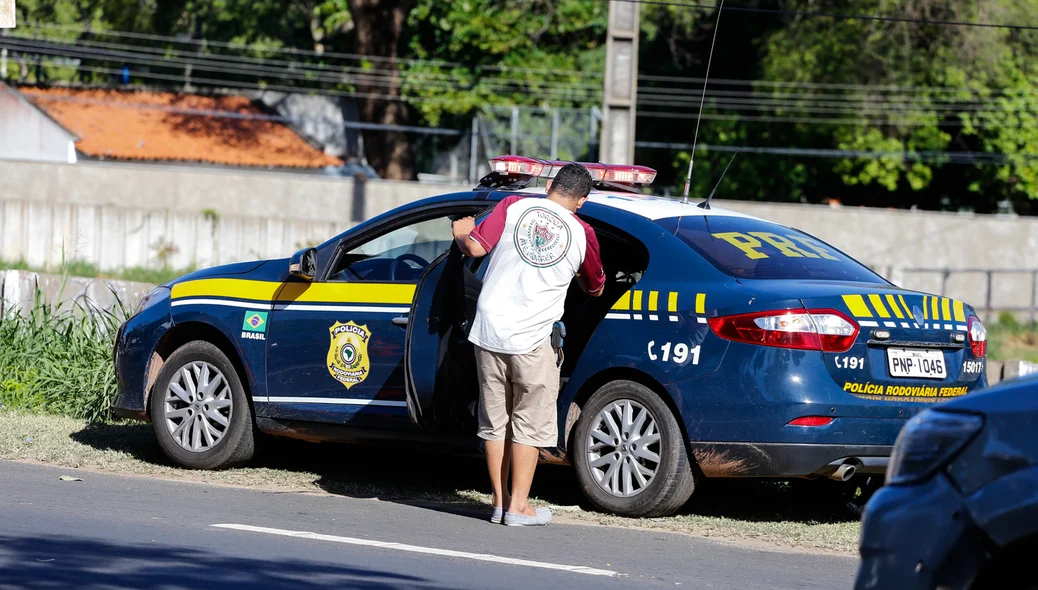 Motorista entrando no carro da PRF 