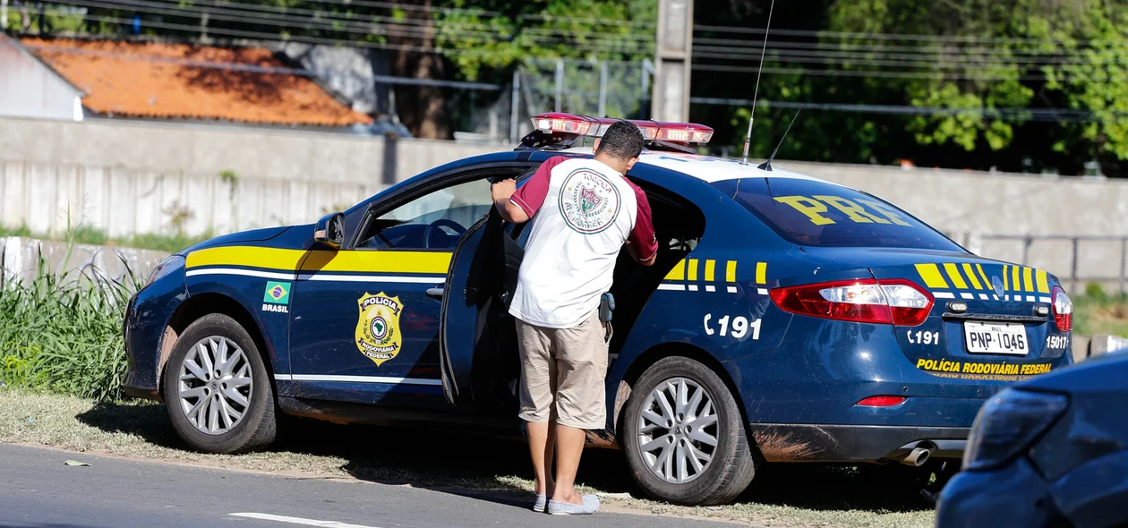 Motorista entrando no carro da PRF 