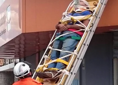 Homem sendo resgatado pelos bombeiros