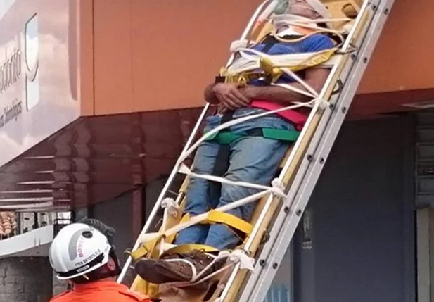 Homem sendo resgatado pelos bombeiros