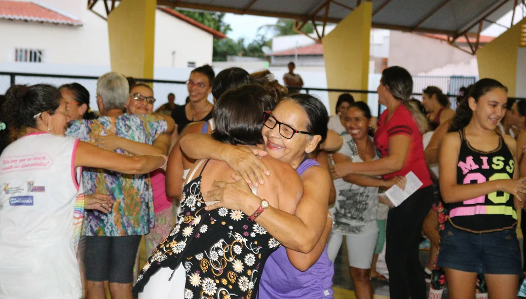Mulheres se abraçam felizes 