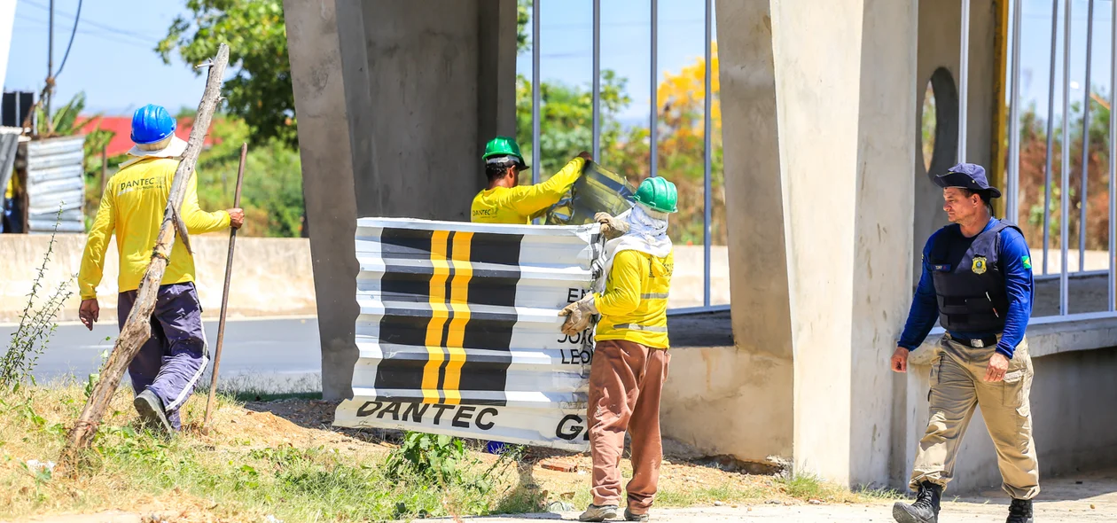 Funcionários retirando placas da obra