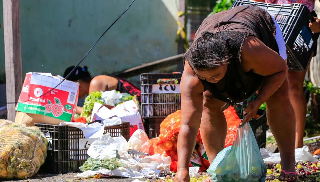 Moradores pegando as frutas espalhadas pelo chão