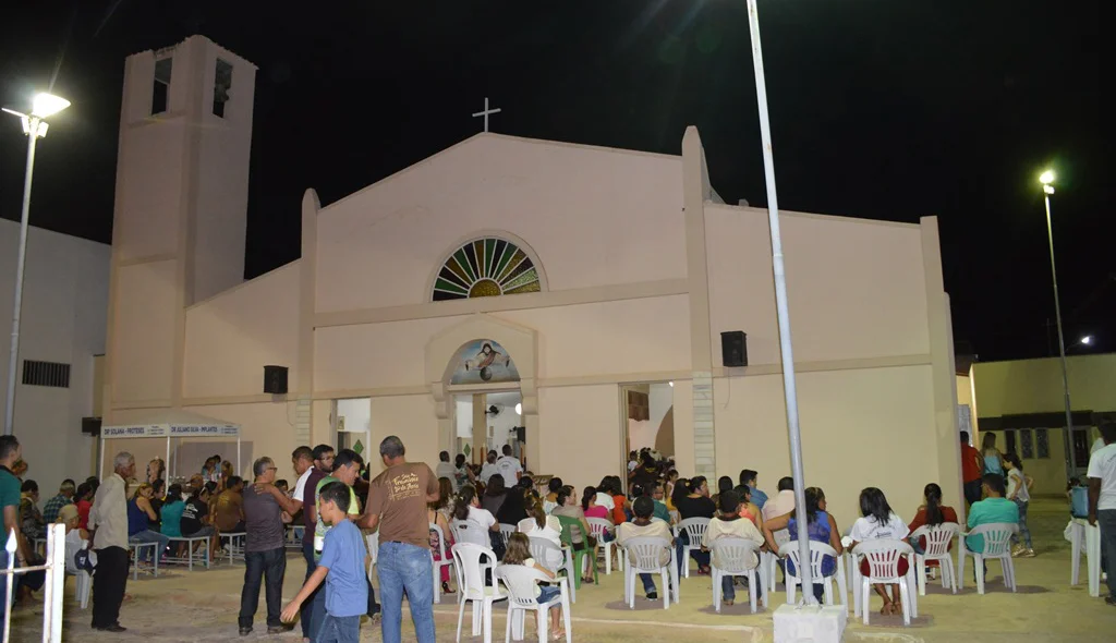 Devido a lotação muitos fiéis assistem a missa do lado de fora da  igreja