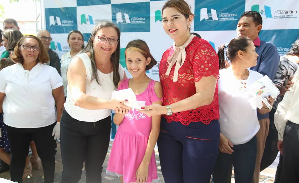 Vilma Amorim e Janaína Marques entrega bolo para criança 