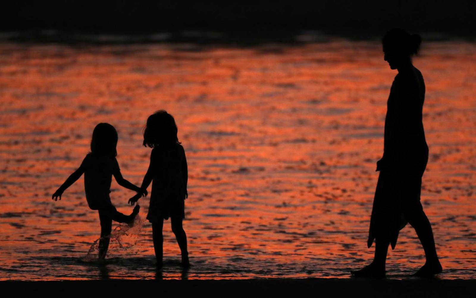 Família se refresca em praia no sul da Califórnia