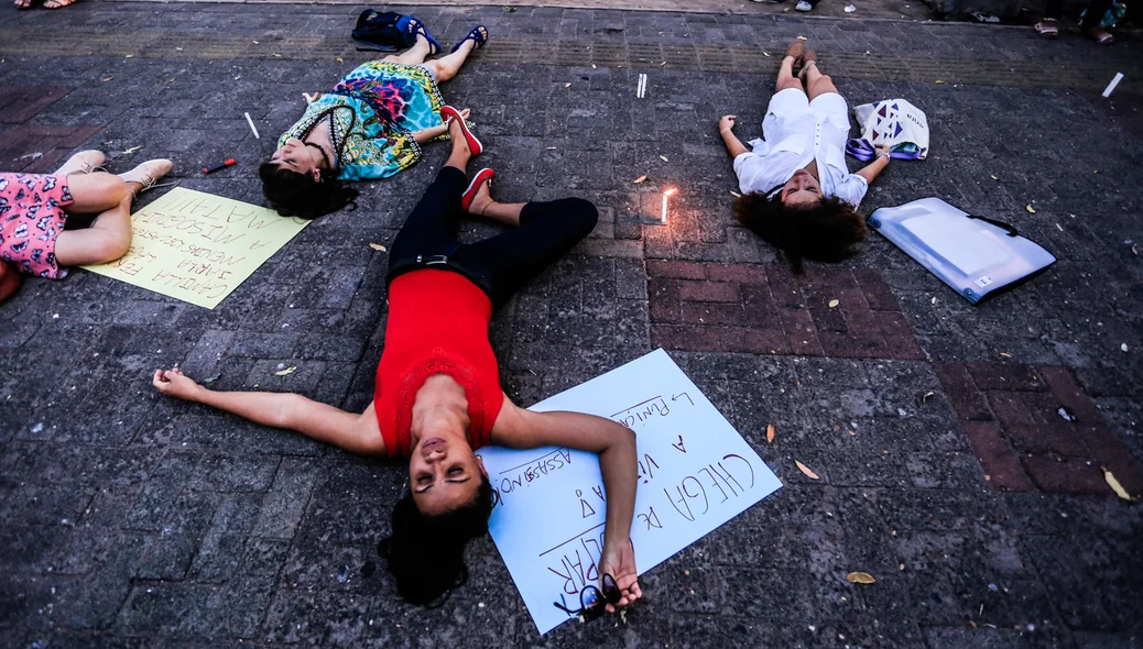 Mulheres deitadas do chão em protesto 