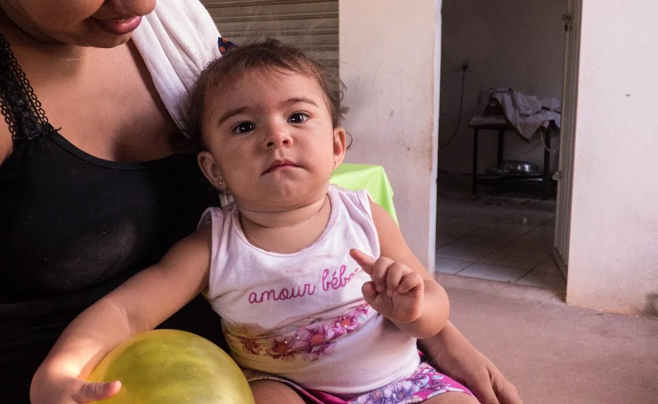 Mãe leva filha para participar do projeto semana da criança