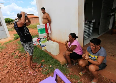 Moradores fazem fila para pegar água em torneira