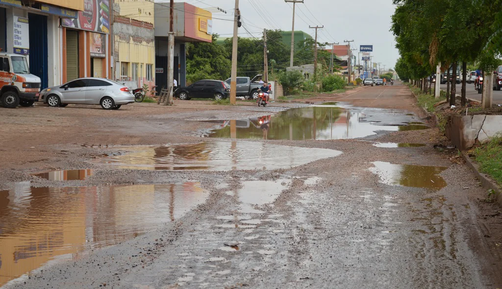 Motociclistas são obrigados a subir na calçada para evitar os buracos