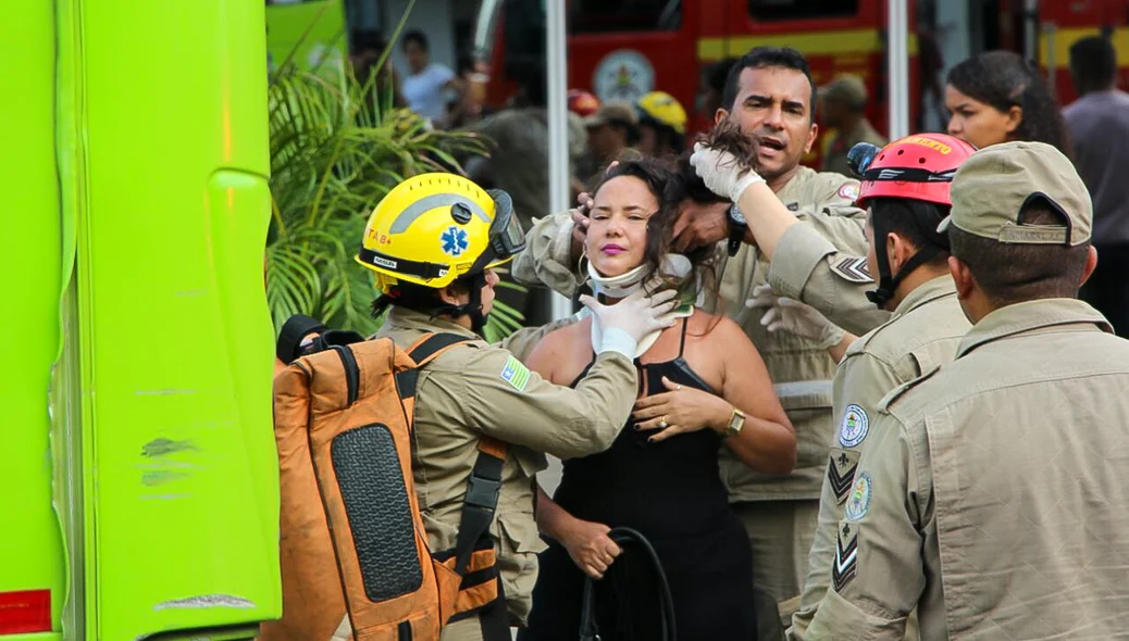 Mulher sendo atendida pelo corpo de bombeiros
