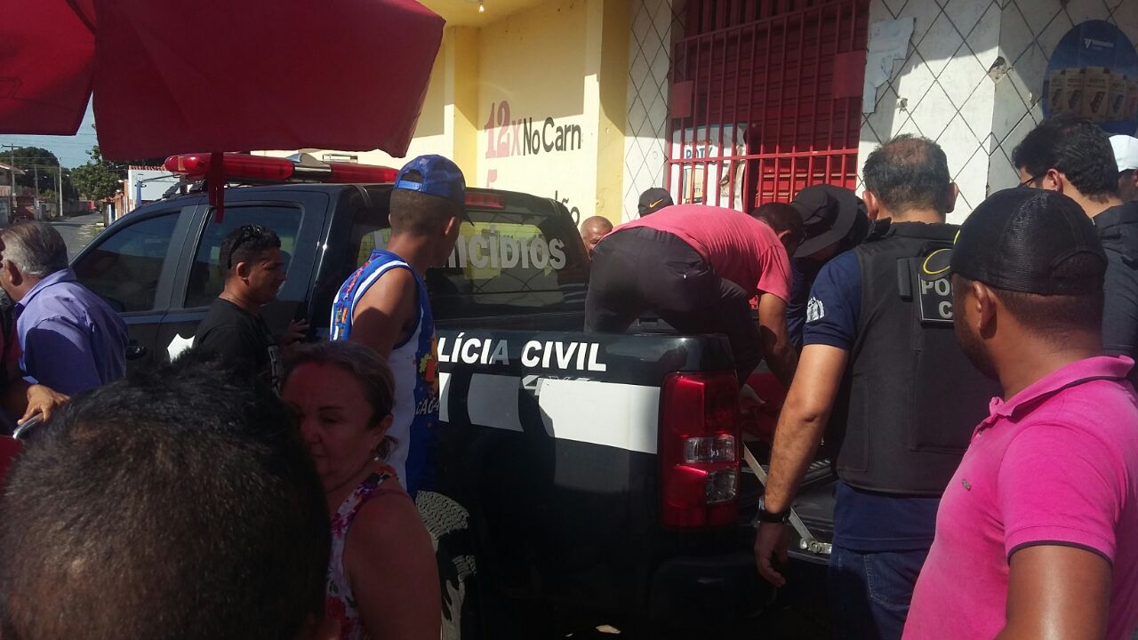 Corpo sendo transportado em viatura da polícia 