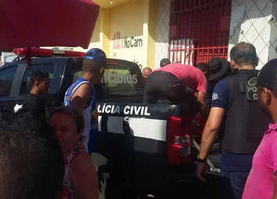 Corpo sendo transportado em viatura da polícia 