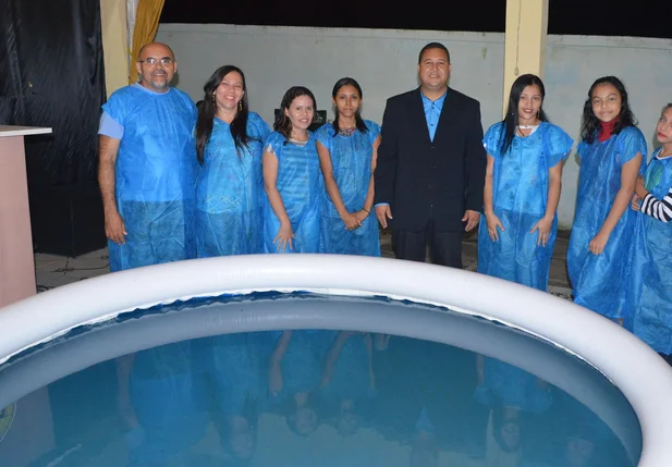 Pastor ao centro com os novos membros batizandos