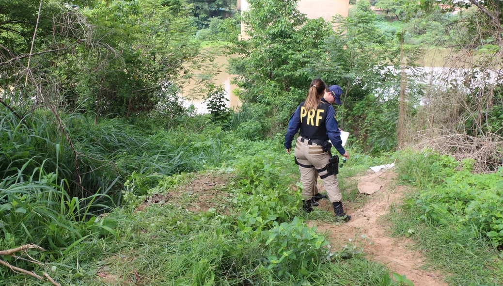 Policiais da PRF fazem levantamentos no local onde o corpo caiu