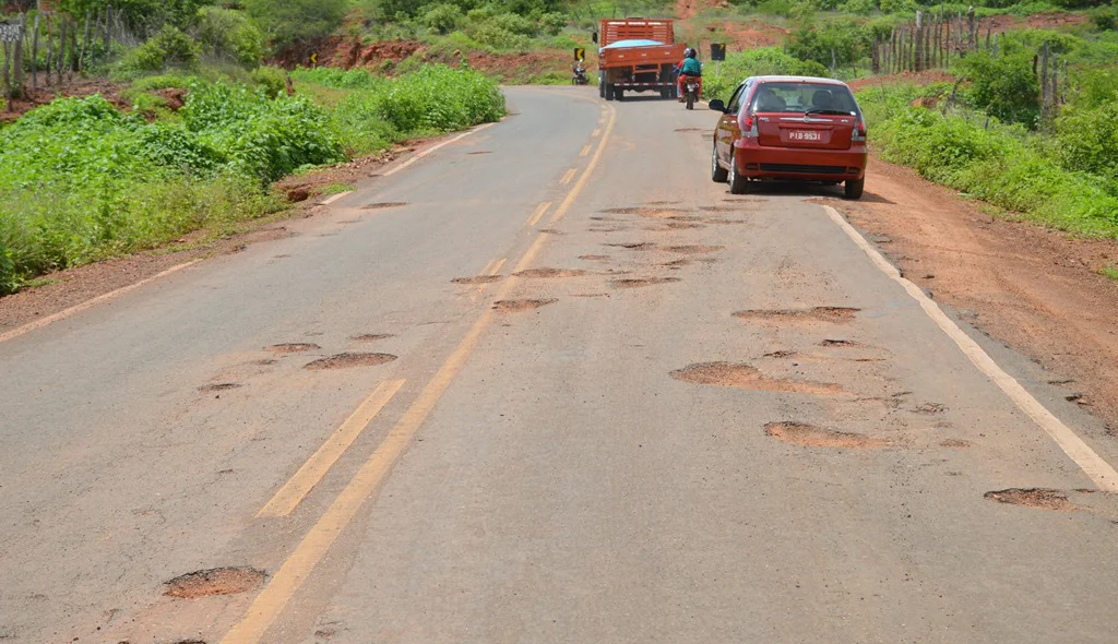 Carros descem da pista para desviar dos buracos