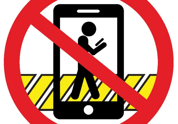 Está proibido atravessar a rua digitando mensagens, falando ao celular ou usando fones de ouvido