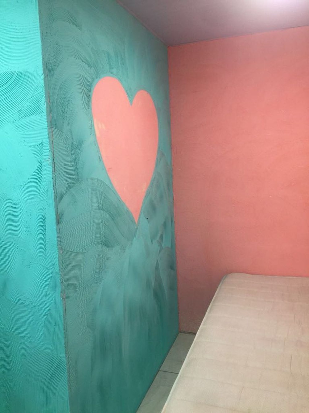 Suíte com parede pintada com coração, na Cadeia Pública de Benfica. 