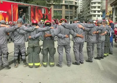 Bombeiros fazem oração após término do trabalho de buscas no desabamento do prédio