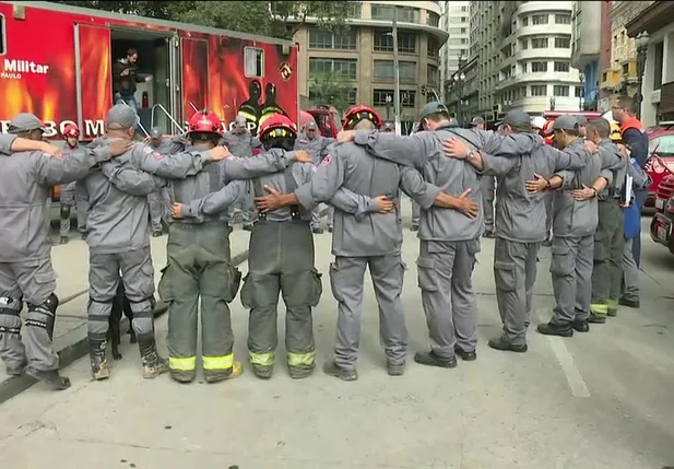 Bombeiros fazem oração após término do trabalho de buscas no desabamento do prédio