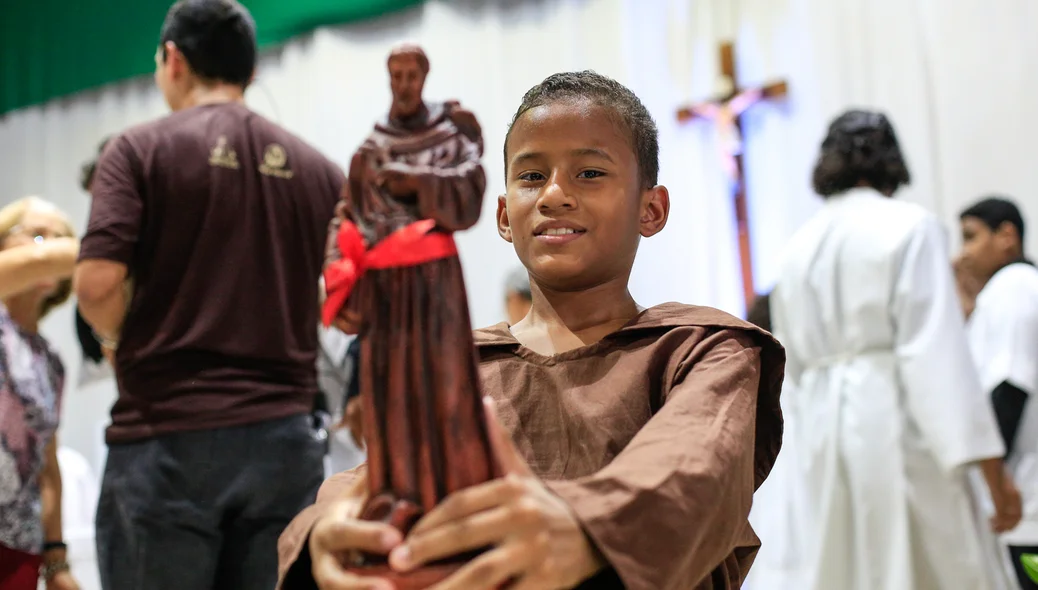 Criança segurando o santo São Francisco de Assis 