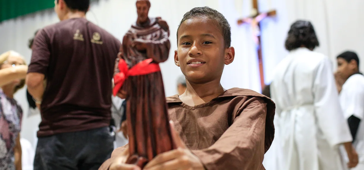 Criança segurando o santo São Francisco de Assis 