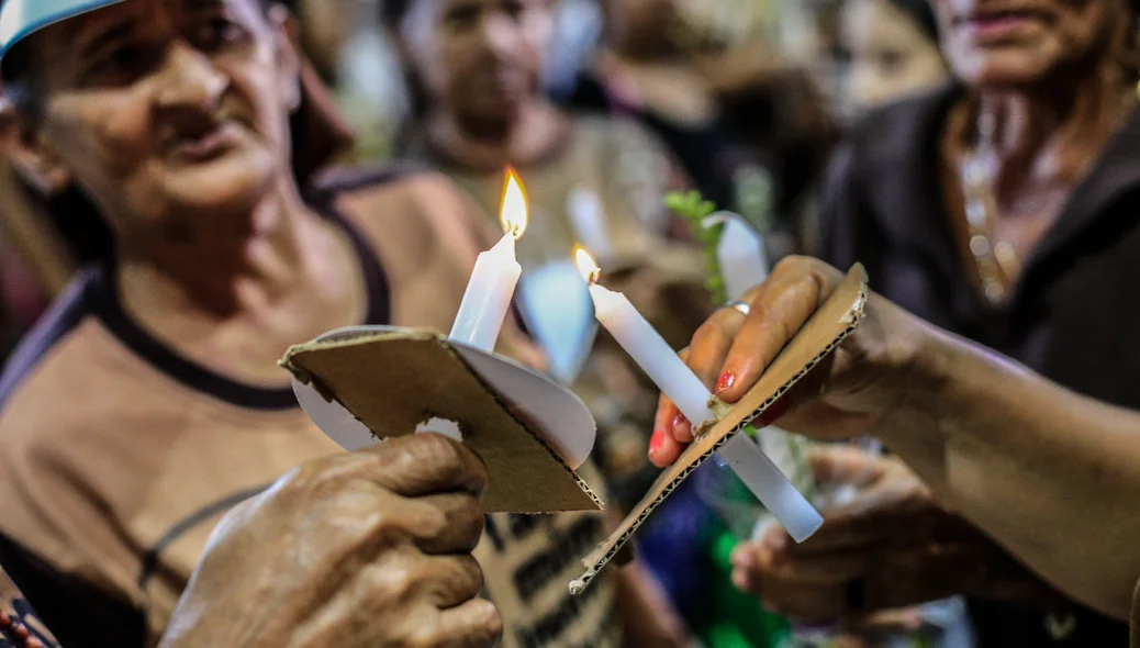 Fiéis acendendo a vela 