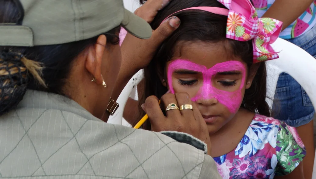 Policial Militar pinta rosto de menina 