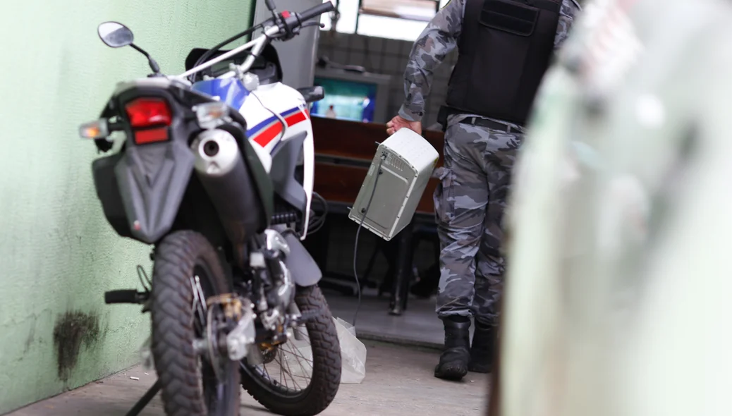 Policial levando os produtos apreendidos 