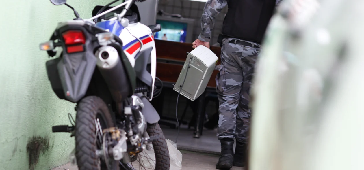 Policial levando os produtos apreendidos 