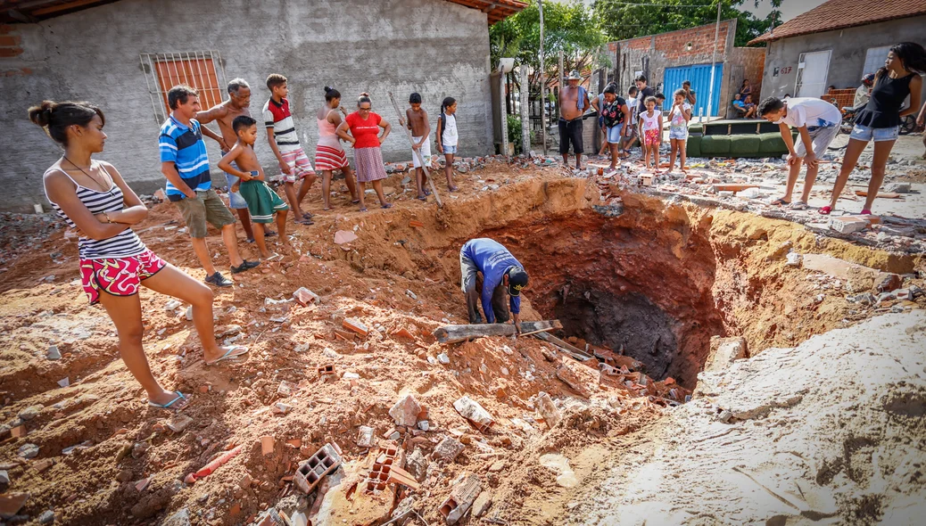 População olhando a cratera no bairro Água Mineral 