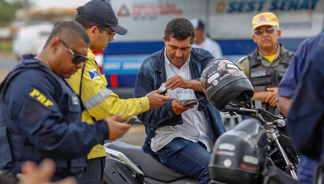 Agente da STRANS conferindo documentação do motoqueiro