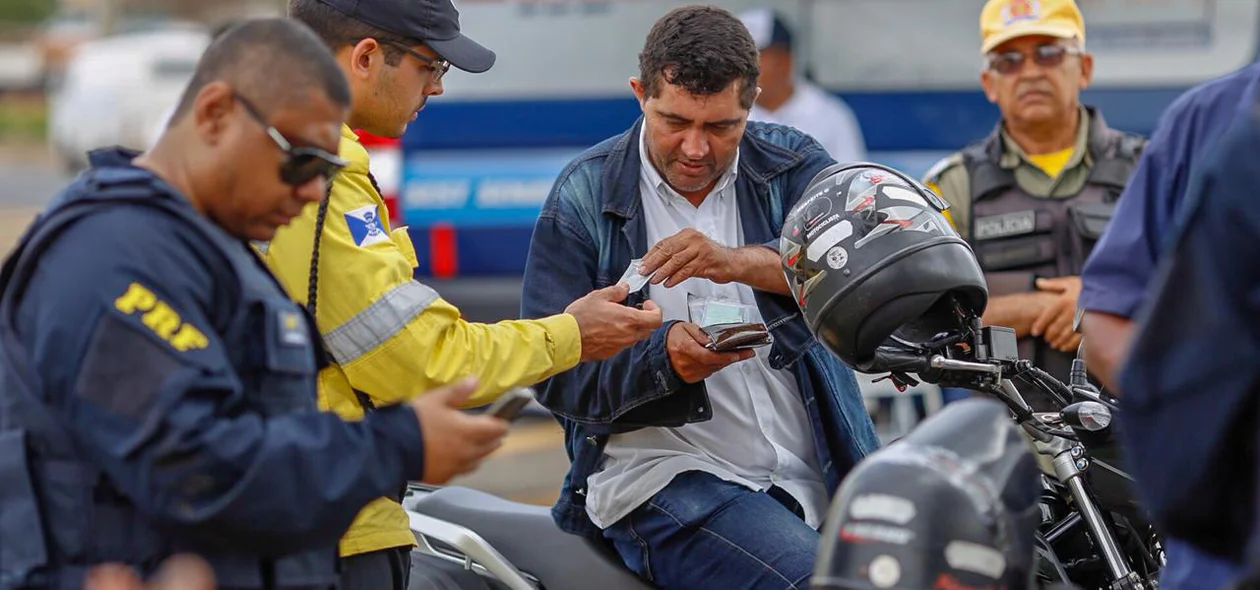 Agente da STRANS conferindo documentação do motoqueiro