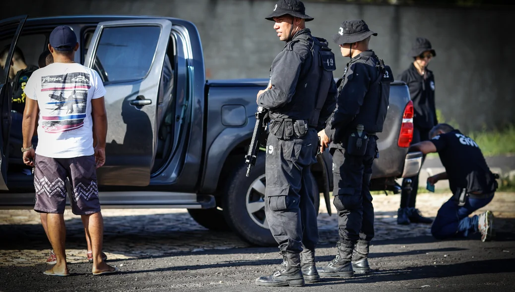 Policiais vistoriando os carros 