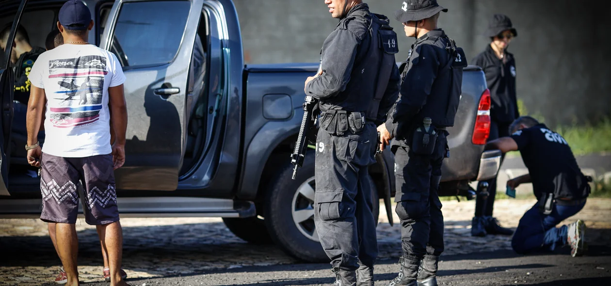 Policiais vistoriando os carros 