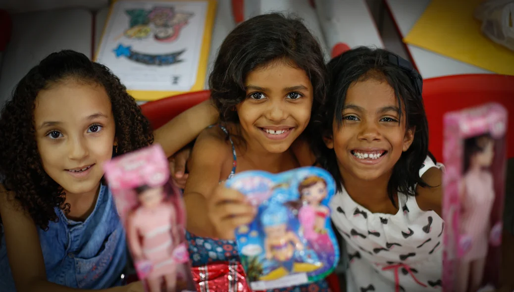 Crianças mostrando os presente que ganharam 