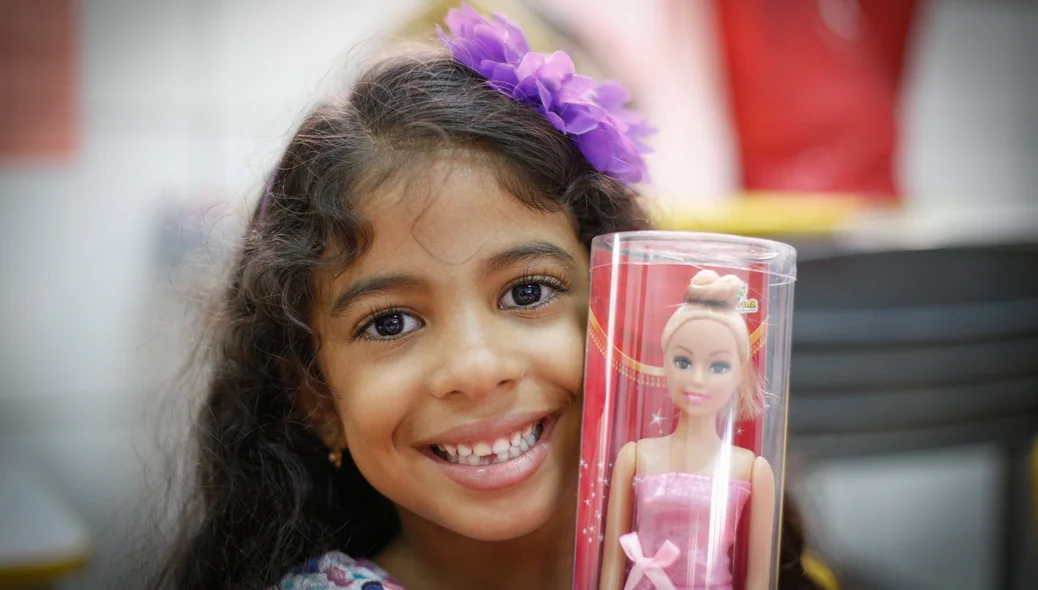 Menina mostrando o presente que ganhou