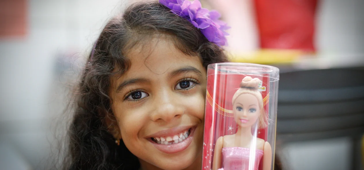 Menina mostrando o presente que ganhou