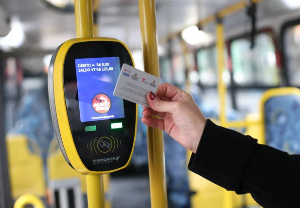 Passageira passa o bilhete único no validador de catraca de ônibus