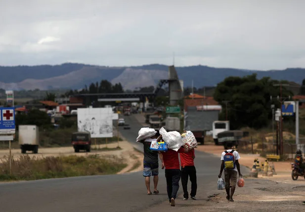 Venezuelanos voltam ao seu país depois de comprar comida na cidade de Pacaraima, em Roraima