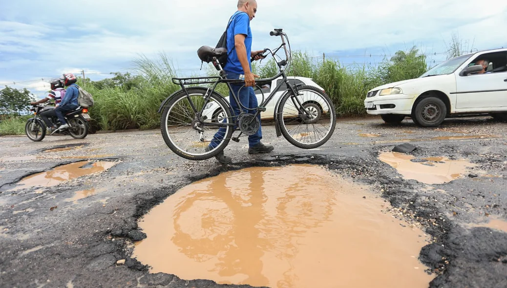 Ciclista levando a bicicleta na mão