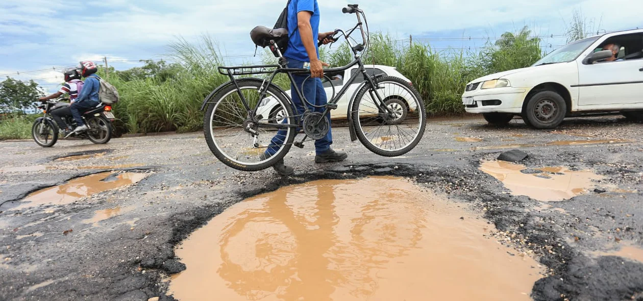 Ciclista levando a bicicleta na mão