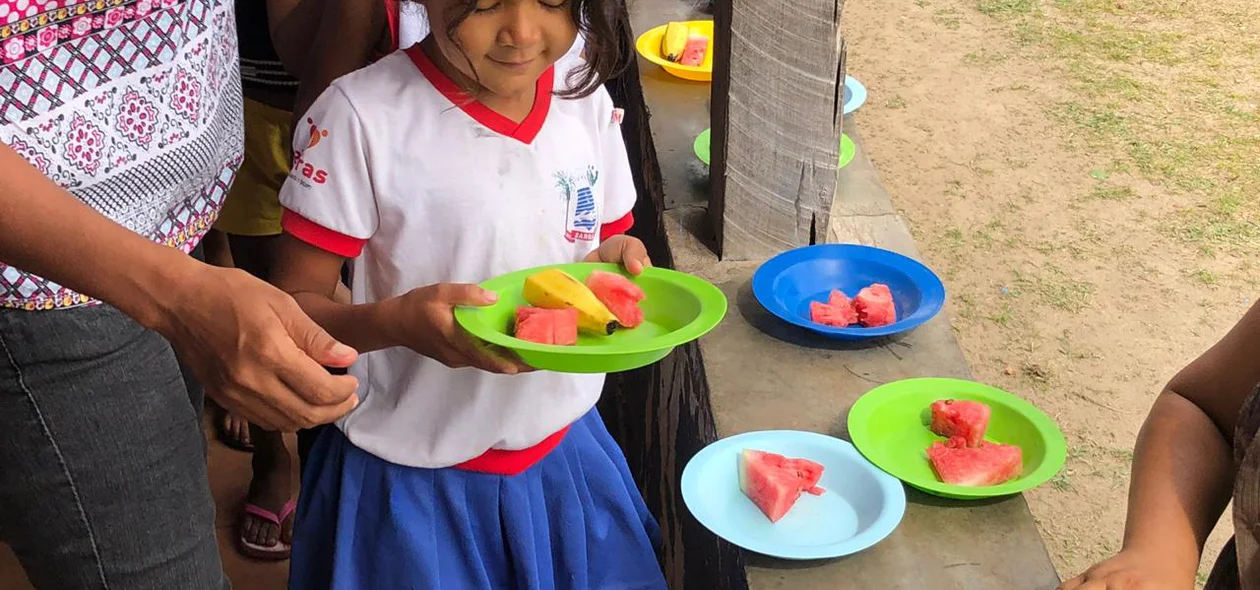Criança recebendo o lanche 
