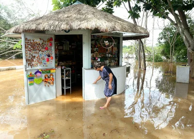 Dona lúcia mostrando onde chegou o nível da água